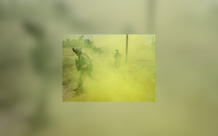 JAV kareiviai bėga sprogus dūminei granatai Irake.