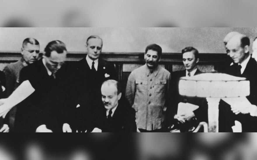 Molotovo-Ribbentropo pakto pasirašymas 1939 m. rugpjūčio 23 d. Prie stalo sėdi Viačeslavas Molotovas, už jo stovi Joachimas von Ribbentropas ir Josifas Stalinas.