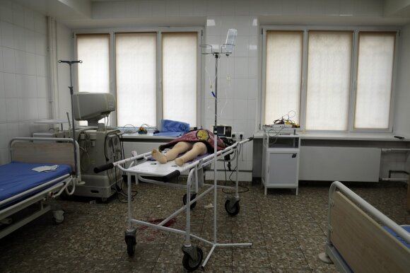2022 m. vasario 27 d., sekmadienį, Mariupolio miesto ligoninėje Rytų Ukrainoje ant medikų vežimo guli per apšaudymą gyvenamajame rajone žuvusios merginos kūnas.